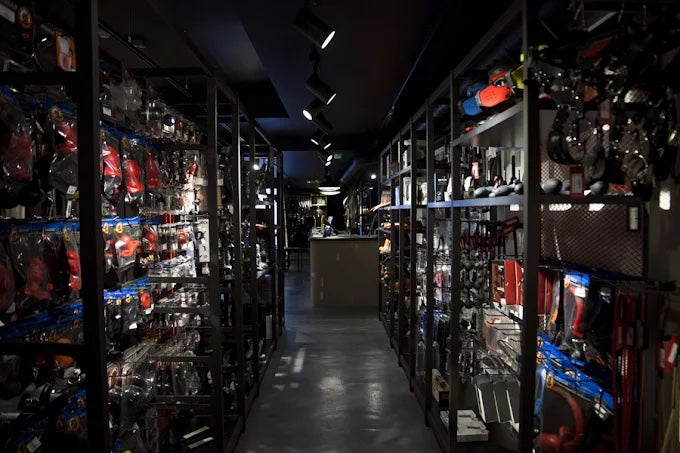An aisle in the Soho shop, shelves of rubber and leather gear under spotlights