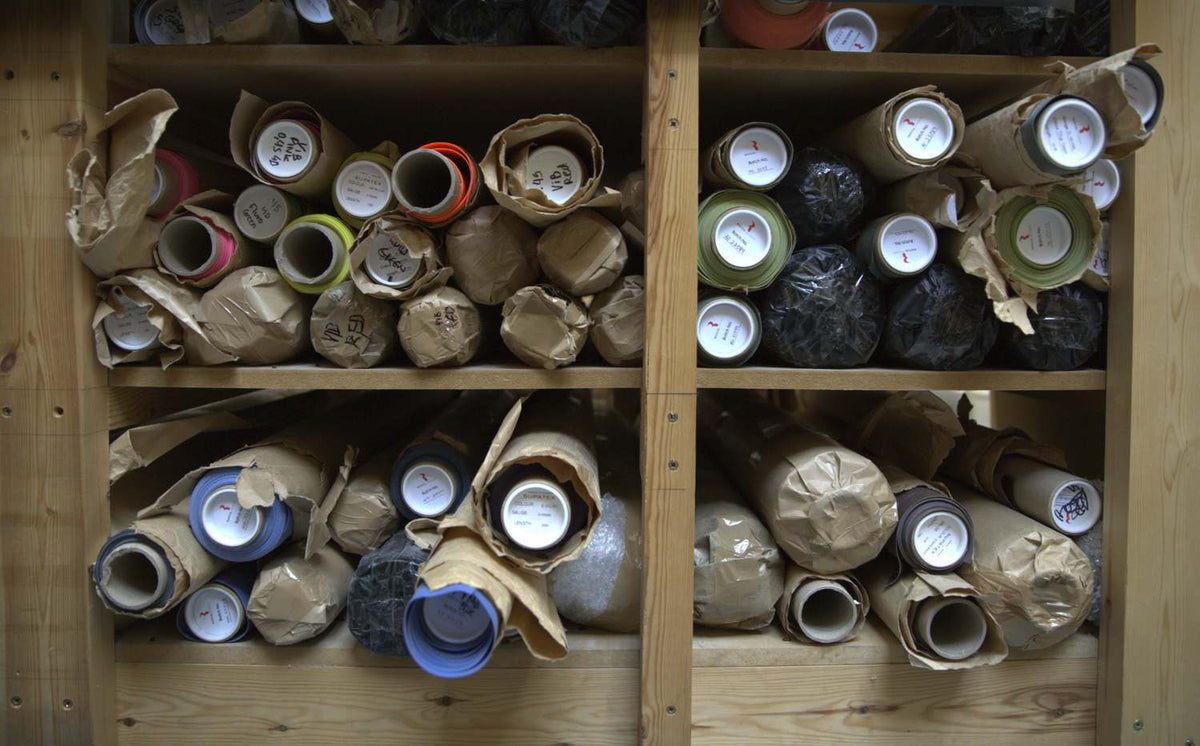 Shelves of rolled latex in paper wrap, colour labelled