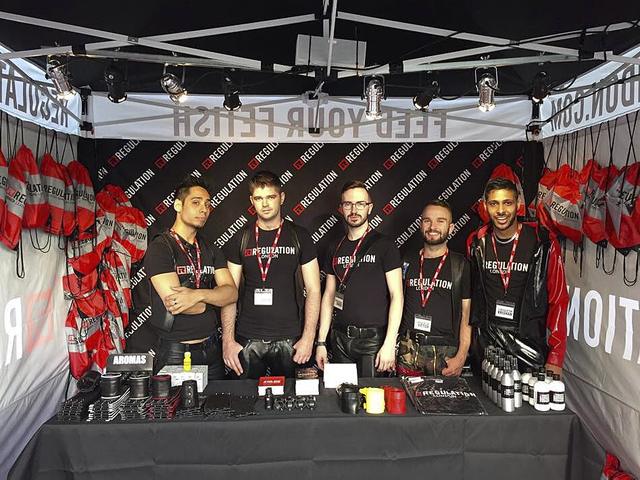 Five REGULATION staff behind the stall table in branded shirts