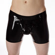 A close-up of a person wearing glossy black latex-style briefs or a pouch-style boxer brief against a plain white background.
